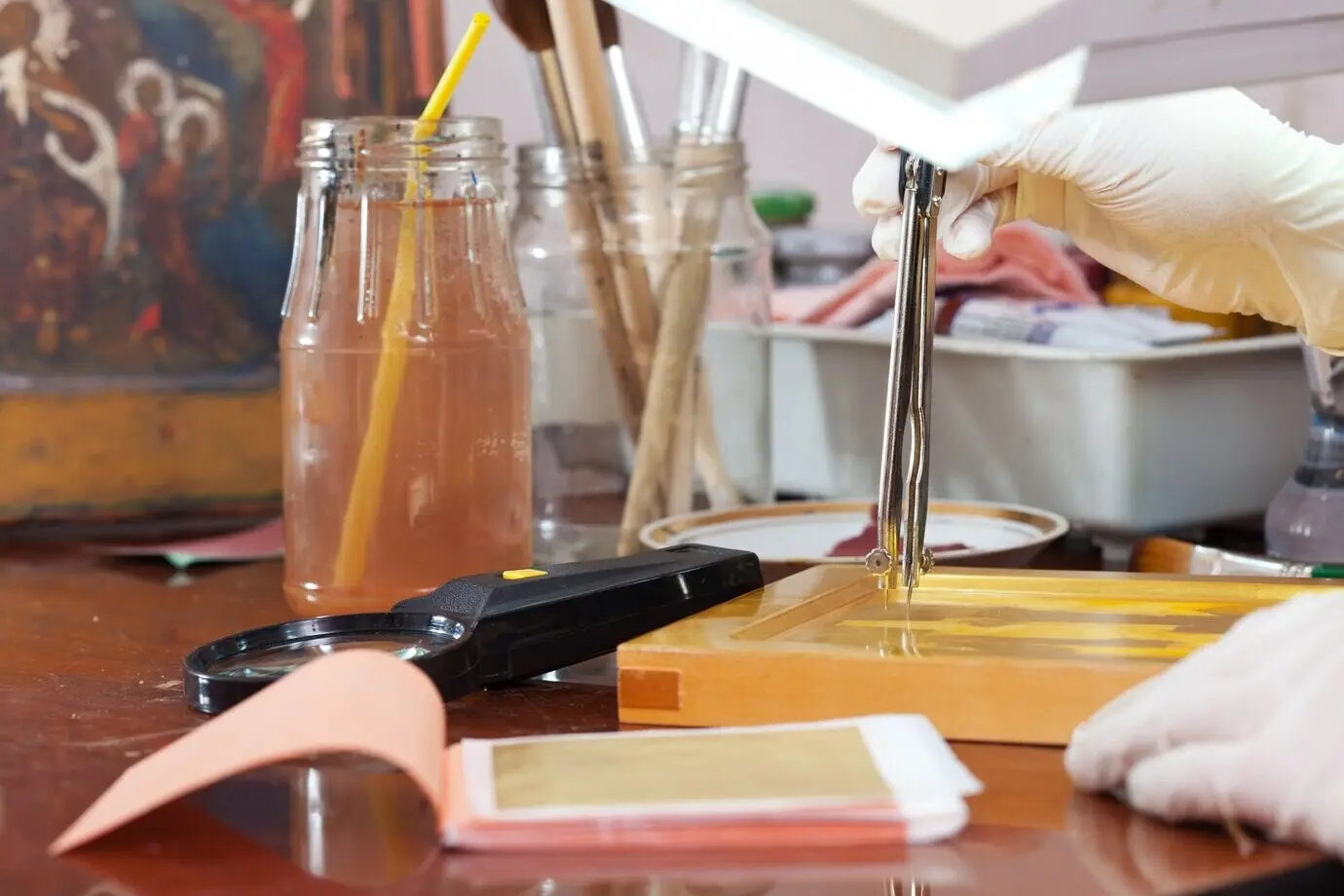 Ein Ikonenmaler arbeitet an einer neuen vergoldeten Ikone.